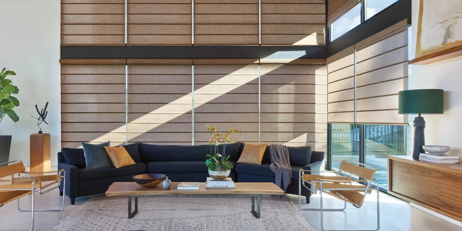 Alustra Architectural roller shades on a two-storey wall of windows