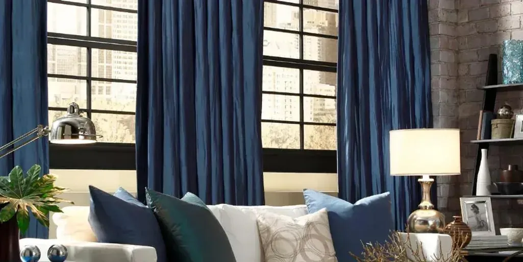 Deep blue drapery panels framing tall windows in a living room