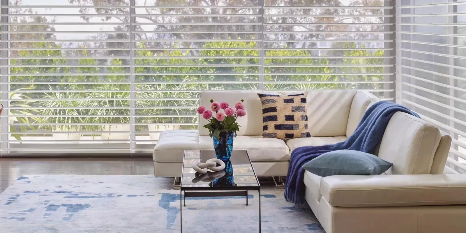 Hunter Douglas sheer shades diffusing daylight across a wall of windows in a bright living room