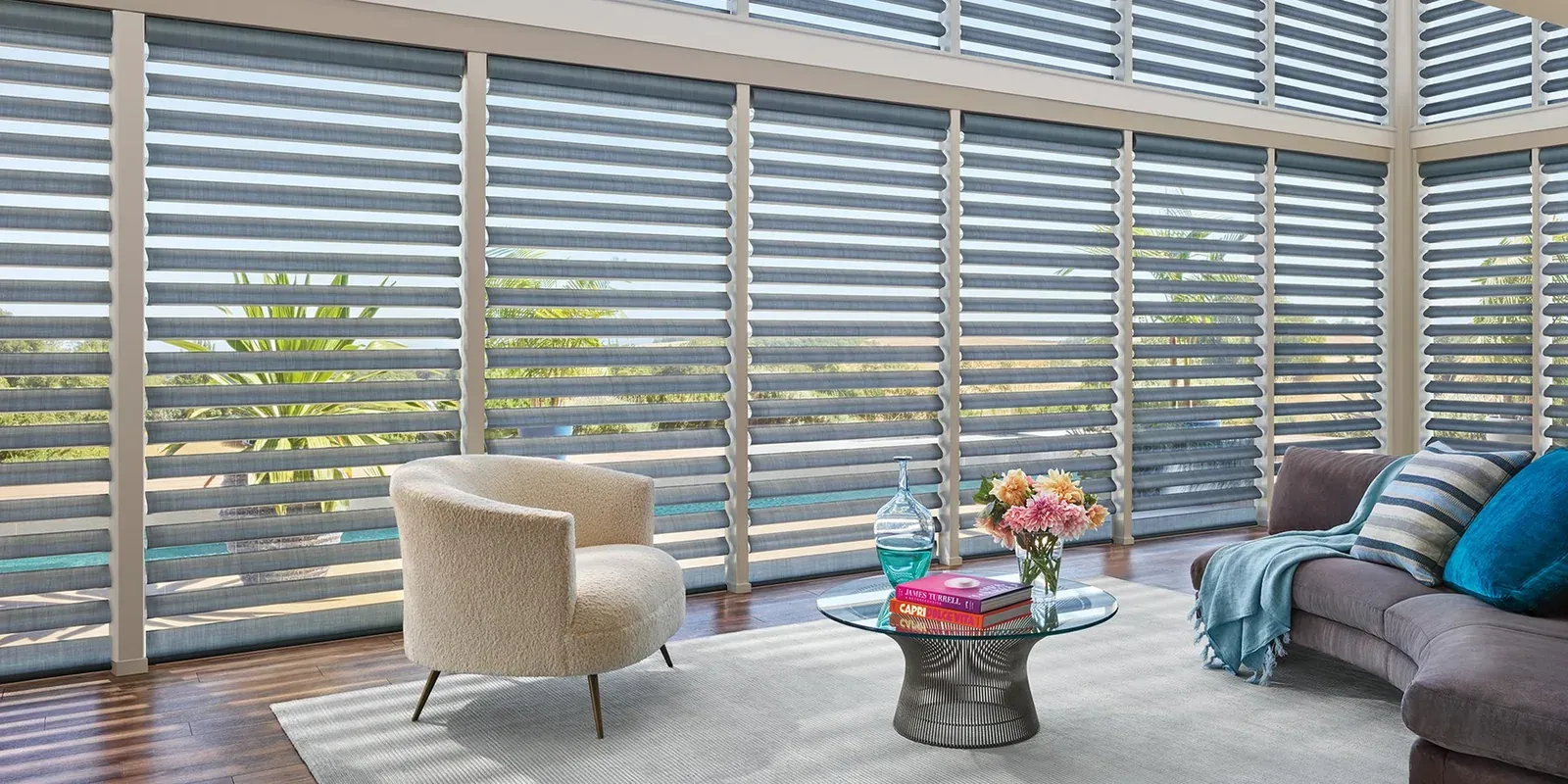 Pirouette sheer shades across a wall of windows in a sunlit living room