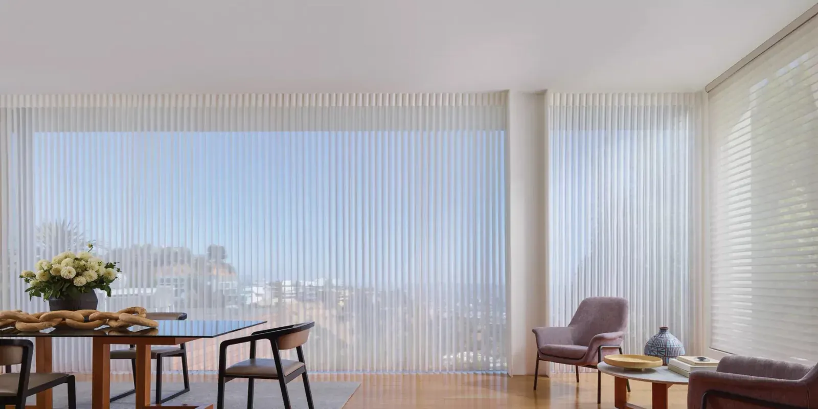Vertical sheer panels across a wall of windows in a dining room